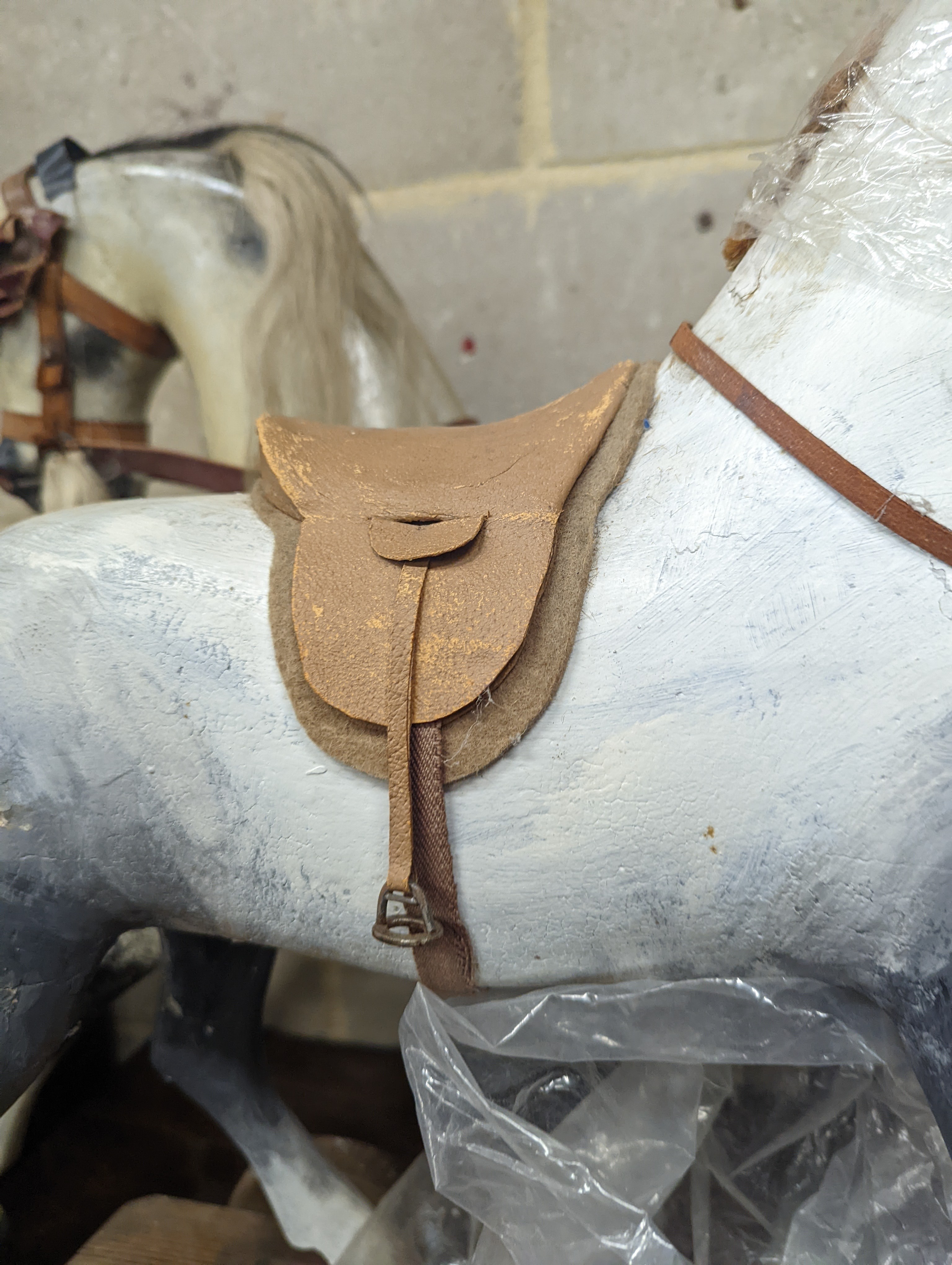 A Victorian carved and painted wood rocking horse, lacking underframe, length 77cm and two painted wood hobby horses, 58cm and 38cm